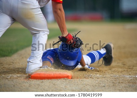 A baseball first baseman tags a base runner out on a pick-off play in a close-up image with space for copy in the upper right of the frame.
