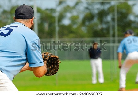Baseball game, first baseman is getting ready to catch a ball from a pitcher, base coach standing in the background.