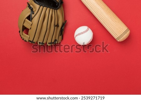 Baseball glove and bat with ball on color background, top view