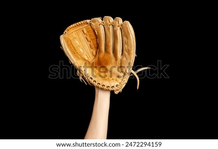 Baseball glove on woman's hand. Black background. Active sports, championship, victory, competition