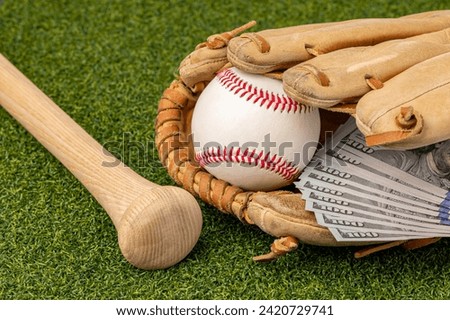 Baseball, glove and wooden bat with cash money. Baseball salary expenses and sports gambling concept.