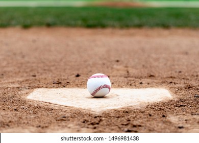 Baseball laying on a worn home plate or base