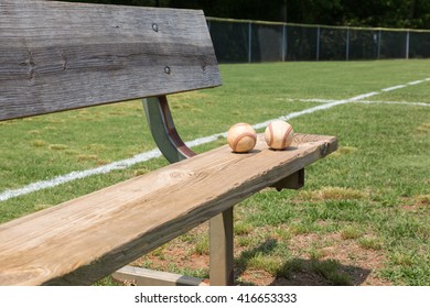 Baseball On A Bench In A Little League Field