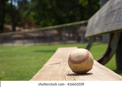 Baseball On A Bench In A Little League Field