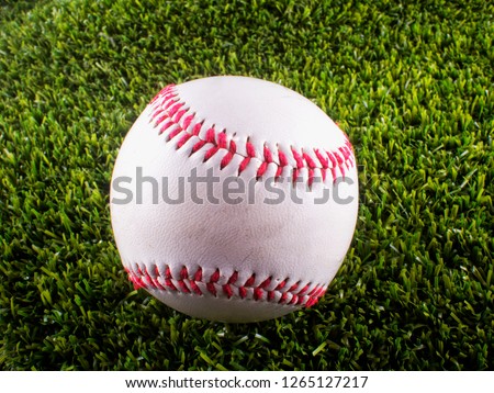 Baseball over synthetic green grass, close up