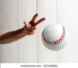 Baseball pitcher, close up of the hand ready to pitch on white wooden background.