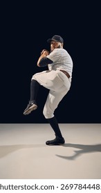 Baseball pitcher in full windup position preparing for throw. Concept of power buildup, pitching technique instruction, and apparel advertising visuals.