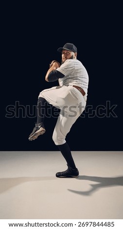 Baseball pitcher in full windup position preparing for throw. Concept of power buildup, pitching technique instruction, and apparel advertising visuals.