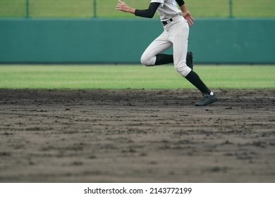 Baseball Player Attempting To Steal A Base During A Baseball Game.