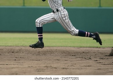 Baseball Player Attempting To Steal A Base During A Baseball Game.