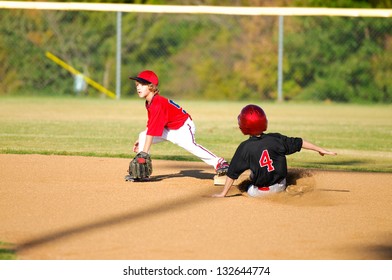 Baseball player getting an out at second base.