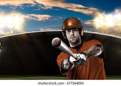 Baseball Player with a orange uniform on baseball Stadium. - Shutterstock ID 477364096