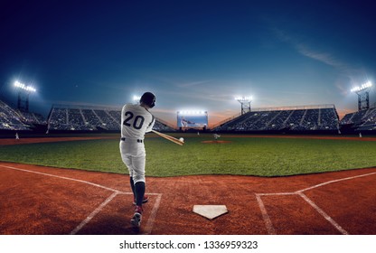 Baseball player at professional baseball stadium in evening during a game.