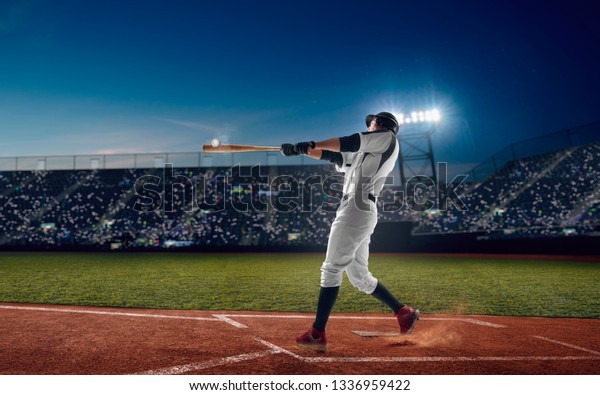 Baseball player at professional baseball stadium in\
evening during a game.