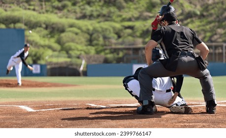 Baseball players in action on the stadium, baseball batter waiting to strike the ball. Baseball pitcher following through to pitch to right handed batter - Powered by Shutterstock