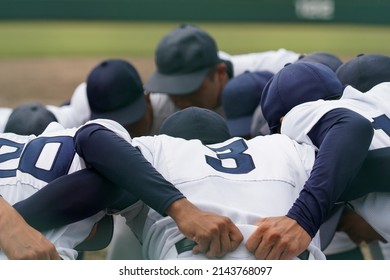 Baseball players form a circle at a baseball game to unify their spirit.