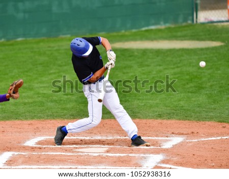Baseball players swinging the bat at a fastball from the pitcher