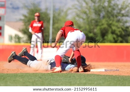 baseball runner diving back to first base on pick off attempt with tag applied to helmet