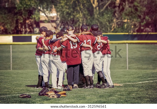 Baseball team in a huddle before a game. \
Instagram toned image.