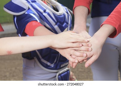 A Baseball Team Puting Hand Together