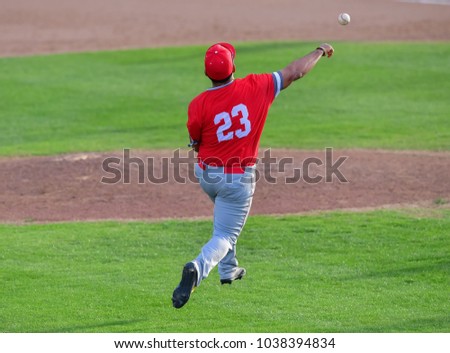 Baseball Third baseman fielding the ball and making a strong throw to first base