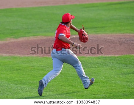 Baseball Third baseman fielding the ball and making a strong throw to first base