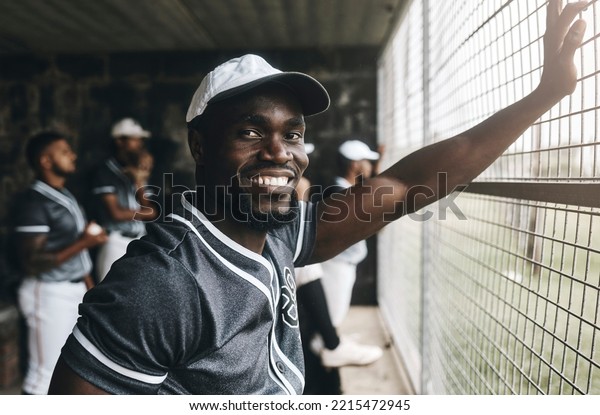 Baseball, training and portrait of coach in dugout,\
smile, relax and happy about sports vision, goal and mission.\
Sport, stadium and cheerful team trainer watching game with\
baseball player group
