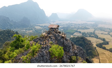 
Based on the image provided, this is a picture of a mountain viewpoint in a mountainous, green landscape. The viewpoint itself is built on a rocky peak and features a small, covered wooden shelter wi