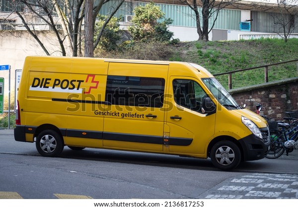 Basel - Switzerland -\
9 March 2022 - Profile view of yellow swiss delivery truck parked\
in the street