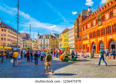 BASEL, SWITZERLAND, JULY 14, 2017: People are strolling on the Marktplatz in front of the red town hall in Basel, Switzerland