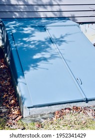 Basement Bulkhead Door On The Side Of A Residential House, Upstate New York. Metallic Door And Newly Painted