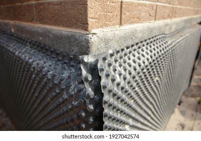 Basement And Foundation Waterproofing: Installation Of The Waterproofing, Dampproofing And Drainage Dimpled Membrane On The Foundation During A House Construction. 