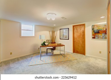 Basement Light Tone Office Room With Desk And Chair In The Corner