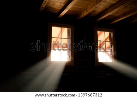 Basement windows in wooden cabin house. Light beams passing through them