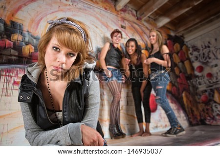 Bashful young woman being teased by group of teenagers