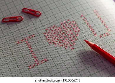 Basic cross stitch pattern I Love You graph paper and red pencil   paper clips  Selective focus 