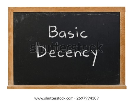 Basic Decency handwritten in white chalk on a black chalkboard isolated in a wooden frame