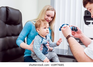 Basic Eye Examination. Mother Holds Child During Eye Exam In Clinic