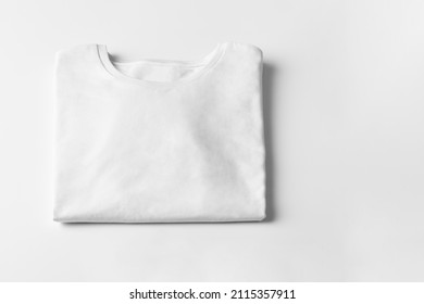 Basic Folded White Tshirt On Grey Table With Copy Space. Mock Up For Branding T-shirt. Monochrome Trend. 