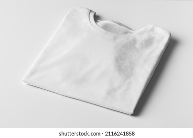 Basic Folded White Tshirt On Grey Table. Mock Up For Branding T-shirt. Monochrome Trend. 