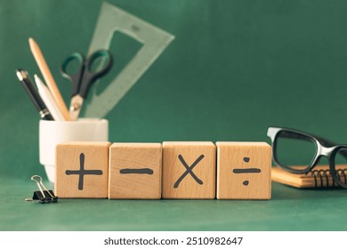 Basic mathematical operation symbols (Plus, minus, multiply, divide) on the wooden cube.  Mathematic, education, back to school concept. Composition for Teacher's day.