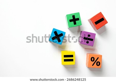 Basic mathematics learning concept. Colorful wooden toy blocks with plus, minus, multiply, and divide symbols for teaching children arithmetic in preschool or elementary school on white background.