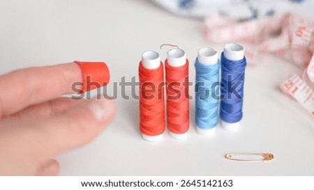 Basic sewing tools with colorful threads and tape for beginner's workshop.