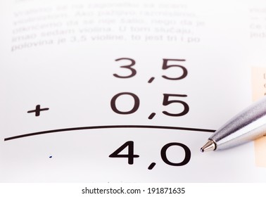 Basic Summing Of Decimal Numbers With Pencil Pointing At Result