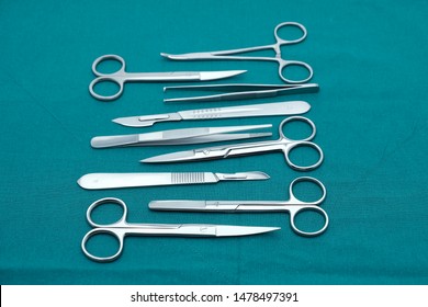 Basic surgical instrument scalpel forceps tweezers scissors on surgical green drape fabric