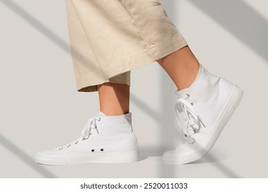 Basic white sneakers unisex streetwear fashion shoot. White canvas sneakers with beige pants, close up. Unisex fashion, casual style. Fashion and clothing concept. - Powered by Shutterstock