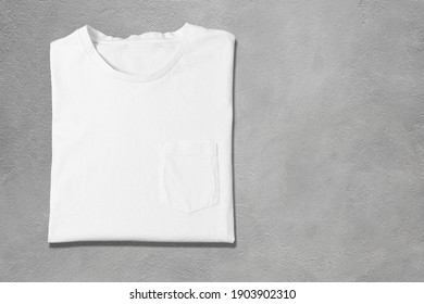 Basic White Tshirt On Grey Concrete Background. Mock Up For Branding T-shirt With Pocket. 