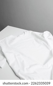 Basic white t-shirt on table. Mock up for branding t-shirt. Copy space