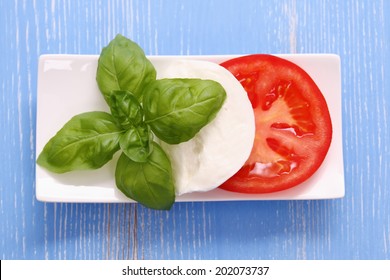 Basil leaf, mozzarella cheese and tomato slice as Italy flag, top view