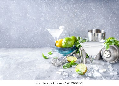 Basil vodka gimlet martini cocktail. Strong alcohol drink with fresh basil, lime and vodka in classic martini glass, Grey stone background copy space - Shutterstock ID 1707299821